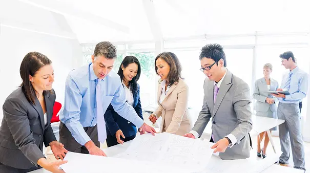 A group of people standing around a table.