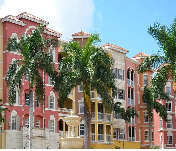 GettyImages-1371154238 A row of buildings with palm trees in front.