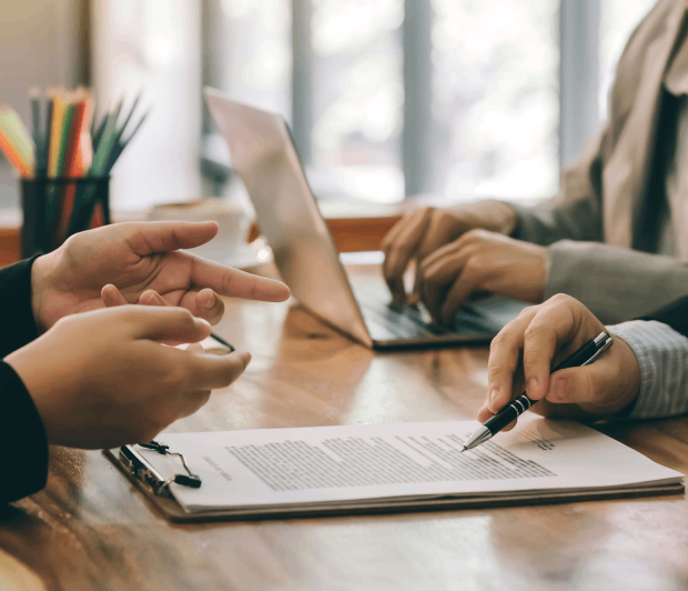 Two people discussing document at table.